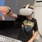 Child with a virtual reality headset on tries to solve a puzzle